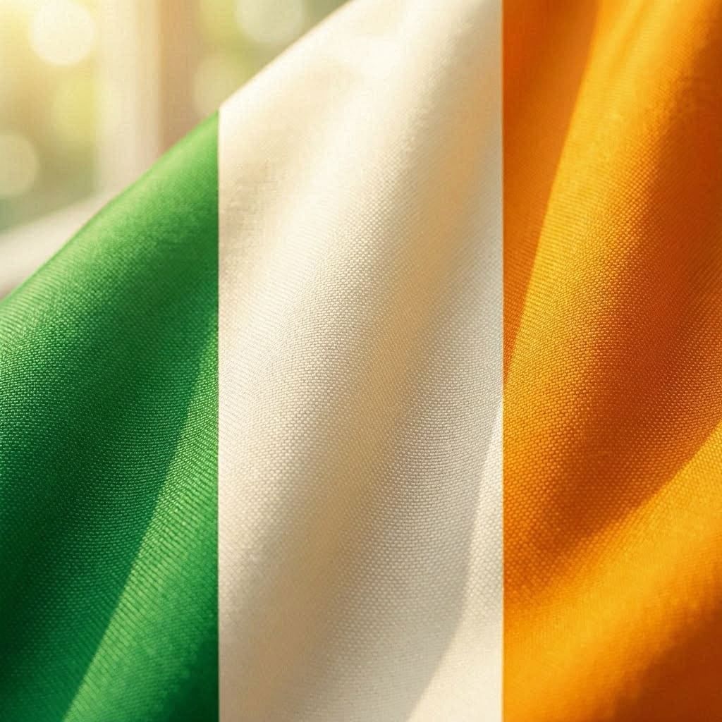 An extreme close-up macro shot of the Republic of Ireland’s green, white, and orange silk flag, showing fine weave texture and gentle folds, illuminated by warm directional light, shallow depth of field with creamy bokeh background, captured using a 100mm macro lens.